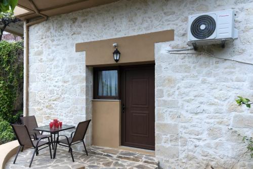 a patio with a table and a brown door at Welcoming apartment with mountain view - 80 m² - Ρούστικα in Roústika