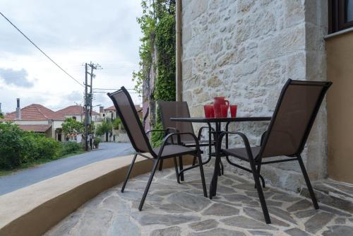 two chairs and a table on a patio at Welcoming apartment with mountain view - 80 m² - Ρούστικα in Roústika