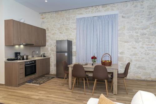 a kitchen with a table and chairs and a refrigerator at Welcoming apartment with mountain view - 80 m² - Ρούστικα in Roústika