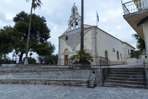 a church with a steeple and stairs in front of it at Welcoming apartment with mountain view - 80 m² - Ρούστικα in Roústika