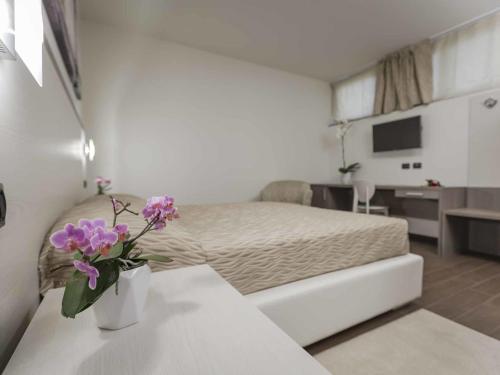 Ferrari Hotel tesisinde bir odada yatak veya yataklar
