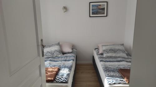 una habitación con 2 camas sentadas una junto a la otra en Apartament Zamkowa, en Puck