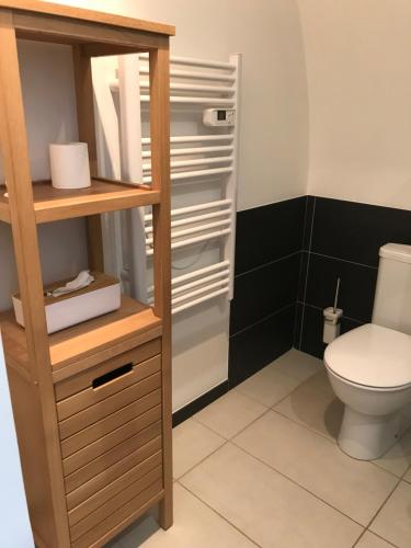 ein Badezimmer mit einem WC und einem Holzregal in der Unterkunft Ma maisonnette in Allauch