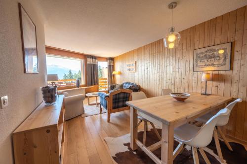a kitchen and living room with a wooden table and chairs at Eden Resort Anzère in Anzère