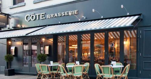 a cafe with tables and chairs in front of a store at West One Studios in Nottingham