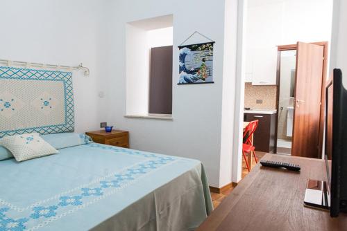 1 dormitorio con 1 cama con colcha azul en Santa Restituta in Cagliari Centre Q4825, en Cagliari