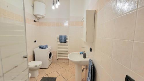 biała łazienka z toaletą i umywalką w obiekcie Viale Umberto I Apartments w mieście Sassari