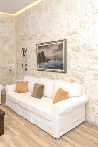 a white couch in a living room with a painting at Welcoming apartment with mountain view - 80 m² - Ρούστικα in Roústika