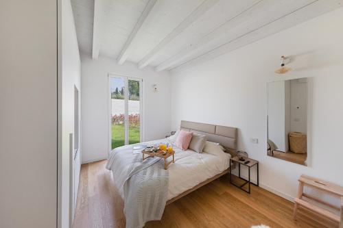 Dormitorio blanco con cama y mesa en La Cittadella PT-6 by Wonderful Italy, en Manerba del Garda