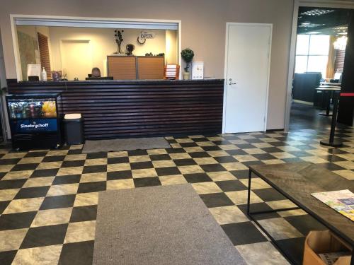 a lobby with a checkout counter and a checkerboard floor at West Side Hotel in Turku
