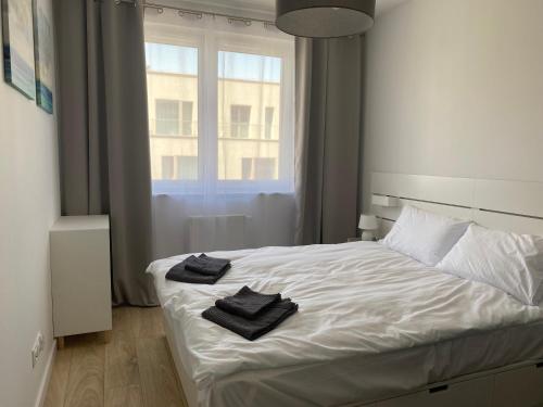 a bedroom with a white bed with two towels on it at Gdańska Duo in Wrocław