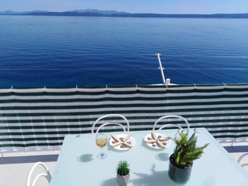 a table on a balcony with a view of the water at Apartment Anđela in Podgora