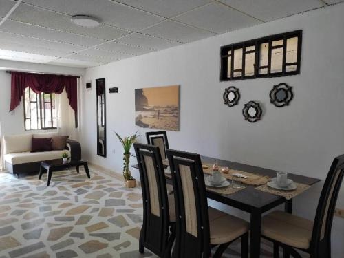 - un salon avec une table, des chaises et un canapé dans l'établissement Alojamiento entero, casa amplia, patio, aire, à Ríohacha