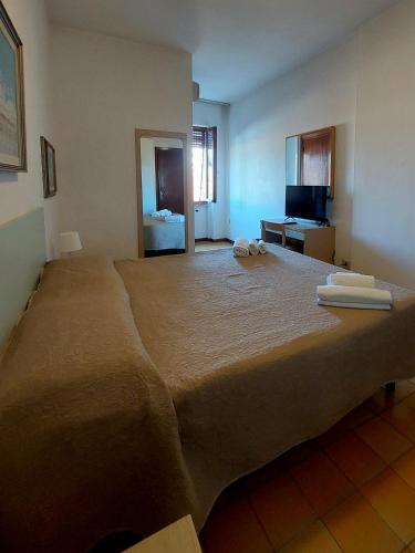 a large bed with two towels on top of it at Hotel San Domingo in Lido di Camaiore
