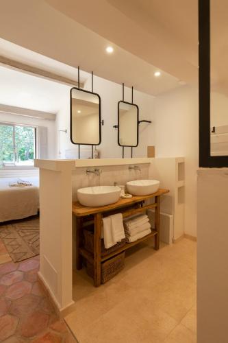 deux lavabos dans une salle de bain avec deux miroirs dans l'établissement Domaine de la Xavolière, à Saint-Cézaire-sur-Siagne