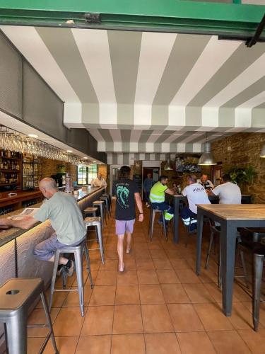 a group of people sitting at tables in a restaurant at A cochera hostel in Ferrol