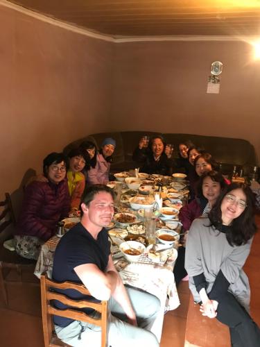 a group of people sitting around a table eating food at Old House in Adishi