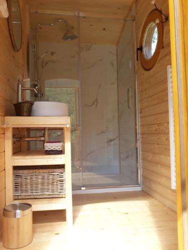 a shower with a glass door in a bathroom at Acabatz de dintrar in Brezons