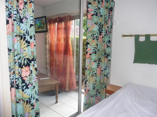 - une chambre avec des rideaux fleuris et une fenêtre dans l'établissement appartement, à Saint-Cyprien