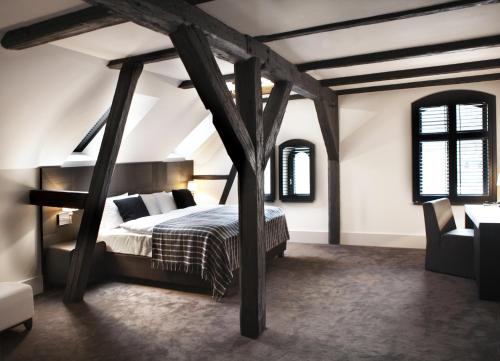a bedroom with a bed in a attic at Hotel Pałac Jugowice in Wałbrzych