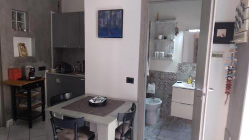 a small kitchen with a table and a refrigerator at Hotel Centrale in Piombino