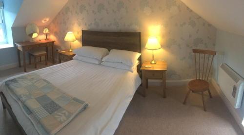 a bedroom with a bed with two tables and two lamps at Cauldholm in Moffat