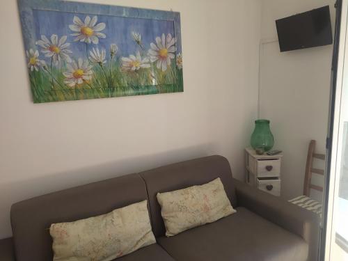 a couch in a living room with a painting on the wall at Da Santina in Pieve Santo Stefano