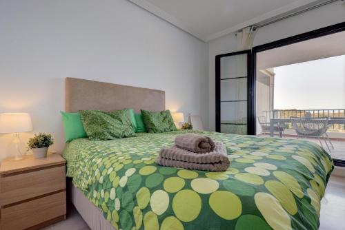 sypialnia z łóżkiem z zieloną i żółtą kołdrą w obiekcie 2 bed-rooms with a view w mieście Benahavís