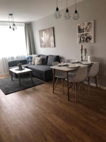 a living room with a table and a couch at Apartament Wejhera Gdańsk Żabianka blisko morza in Gdańsk