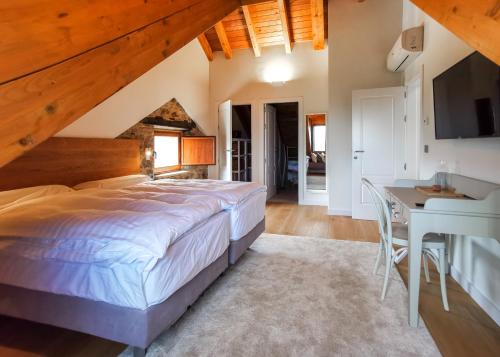um quarto com uma cama grande e uma mesa em Hotel Boutique Finca esencial em Villafranca del Bierzo