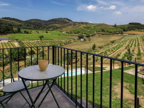 a table on a balcony with a view of a vineyard at Boutique Finca esencial Hotel Rural in Villafranca del Bierzo