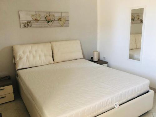 Cama en habitación con marco de cama blanco en La casa di Alice è un bilocale luminoso e felice, en Porto Empedocle