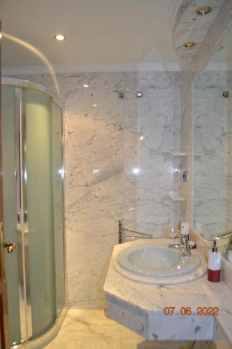 a bathroom with a glass shower and a sink at Casa Rural Villa Herrera in Fernancaballero