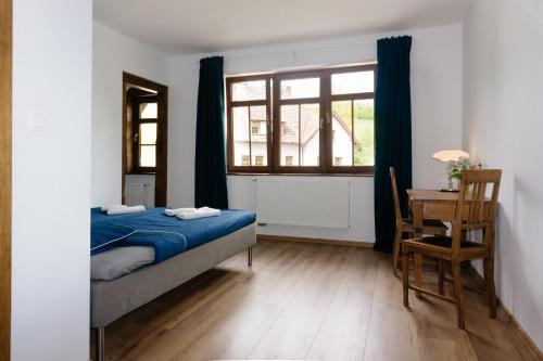 a bedroom with a bed and a desk and a window at Ośrodek Wypoczynkowy Maria w Lewinie Kłodzkim - MARIA I in Lewin Kłodzki