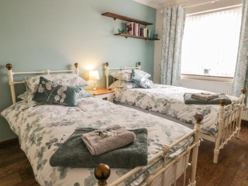 a bedroom with two beds and a window at Lilly May Cottage in Bridlington
