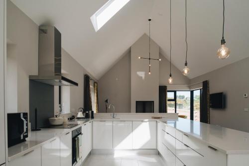 a kitchen with white cabinets and a large kitchen island at Lamb Cottage in Ballycastle