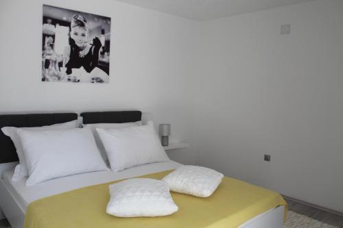 a white bed with two pillows on top of it at Apartment River in Klis
