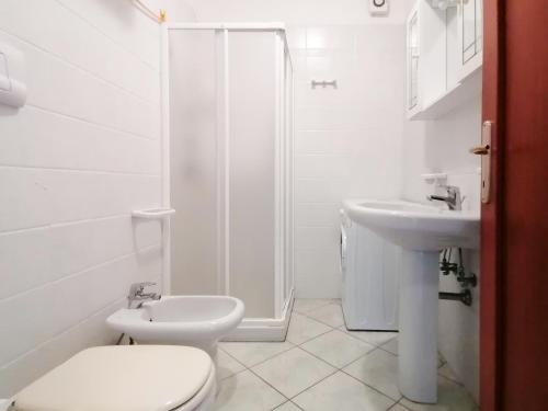 een witte badkamer met een toilet en een wastafel bij Residence Olimpo Poseidone in Santa Teresa Gallura
