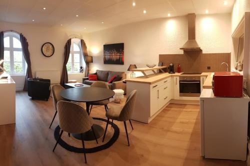cocina y sala de estar con mesa y sillas en Appartement vue panoramique, sur les hauteurs de Lons, en Lons-le-Saunier