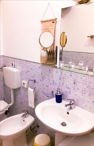 a bathroom with a sink and a toilet and a mirror at B&B MaryJosè in Trapani