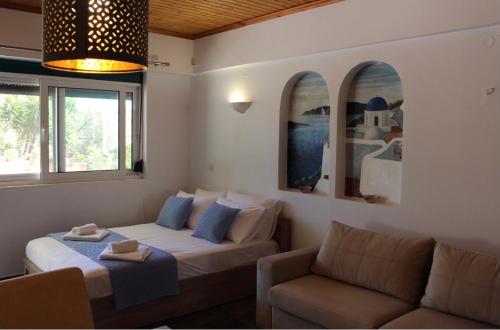 a living room with a bed and a couch at Corali Luxury Beach Apartment in Poros