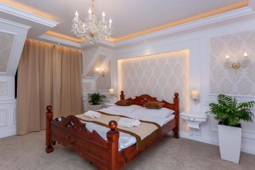 a bedroom with a large bed and a chandelier at Boutique Hotel Budzak in Ždiar