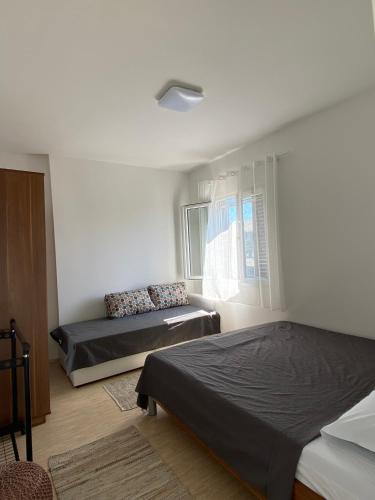 a bedroom with two beds and a window at Acacia apartmani Sutomore in Sutomore