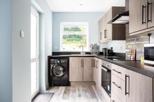 Una cocina con lavadora y secadora. en Fully refurbished North Belfast Home 3, en Belfast