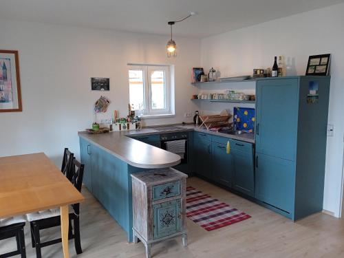 フリンブルクにあるLipno - Villa Bernard - Lakeside Villageのキッチン(青いキャビネット、木製テーブル付)