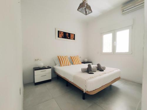 a white bedroom with a bed and a window at CENTER & WHITE TOWN Apartament in Torremolinos