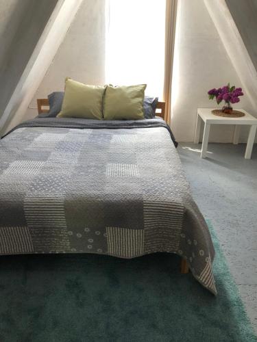 a bedroom with a large bed and a table at Piejūras Namiņš in Ragaciems