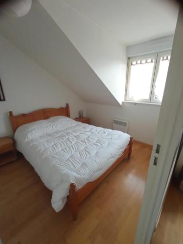 sypialnia z łóżkiem z białą pościelą i oknem w obiekcie Appartement au coeur de Luchon w mieście Luchon