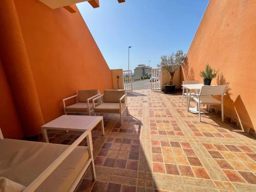 a row of tables and chairs on a patio at El Alamillo ground floor apartment with sea view in Mazarrón