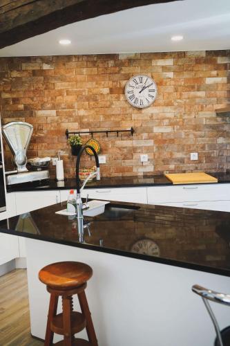 a kitchen with a clock on a brick wall at Casa do Avô Horácio in Viana do Castelo